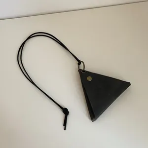 Macro view of triangular dark gray leather glasses pouch with vintage brass button snap