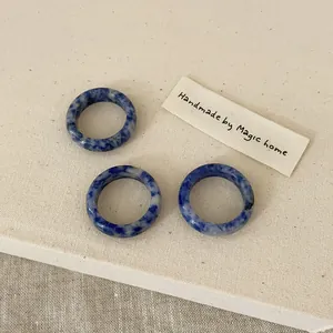 Detailed view of three handmade round natural blue stone rings with marbled texture