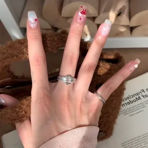 Gros plan de bagues entrelacées en argent brossé avec zircons portées par un mannequin