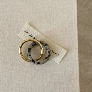Double-layered vintage metal ring set with grey spotted stone on beige fabric base