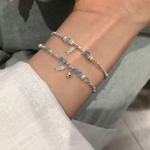 S925 silver beaded bracelet with blue crystal fish charm and pearl on female wrist