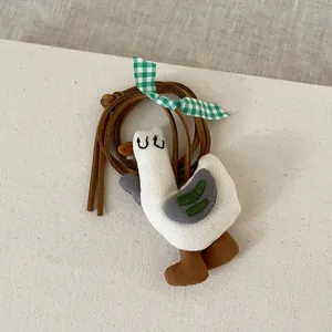 Vue détaillée du pendentif canard en tissu fait main avec broderie et nœud à carreaux