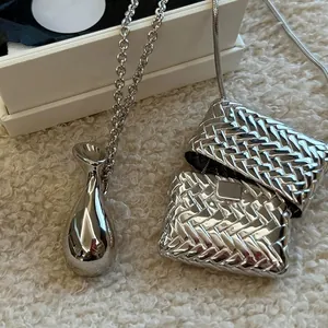 Pendentif sac tissé argenté et collier goutte sur boîte cadeau élégante blanche