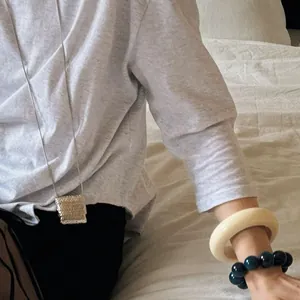 Gros plan d'un collier à pendentif en métal tressé avec des bracelets en résine et perles