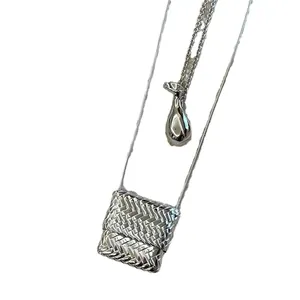 Colliers longs minimalistes avec pendentifs sac tressé et goutte argentés sur blanc