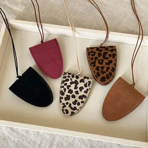 Close-up of leopard print and leather magnetic sunglasses holder necklaces with lanyards