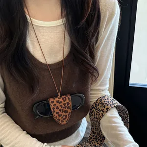 Detail of leopard print sunglasses pouch necklace on model with magnetic closure