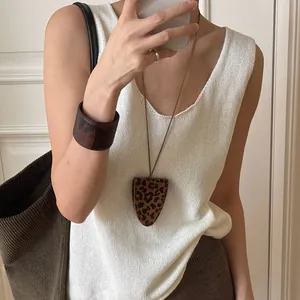 Close-up of leopard print teardrop pendant and V-neck knit top for casual style