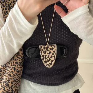 Close-up of leopard print magnetic sunglasses holder necklace on white shirt