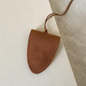 Detail of tan suede magnetic eyewear holder necklace with fine stitching and slim strap