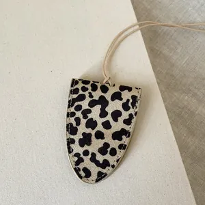 Macro detail of the leopard print fabric texture and fine stitching on the neck strap