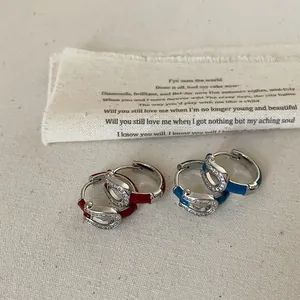 Macro shot of horseshoe earrings with colorful enamel and sparkling cubic zirconia