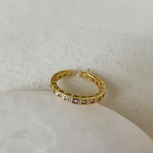 Macro detail of gold adjustable ring featuring colorful square-cut inlaid gemstones