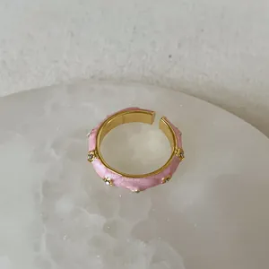 Detailed close-up of adjustable pink enamel flower ring with sparkling rhinestones