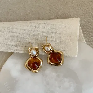 Vintage gold irregular earrings with faux pearl and amber resin stone in elegant style