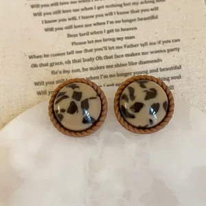 Close-up of vintage leopard print resin stud earrings with twisted brown border detail