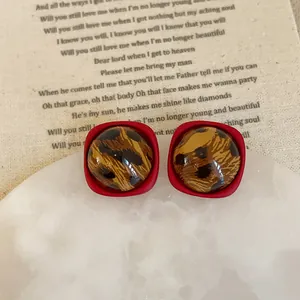Detailed view of vintage leopard print resin earrings on a classic white stone display