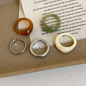 5-piece geometric resin and metal ring set in amber brown, cream white, and green