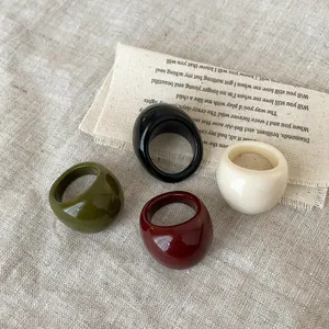 Set of four minimalist oval resin rings in green, burgundy, white, and black colors