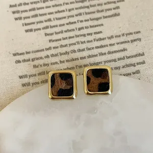 Close-up of leopard print resin earrings with elegant gold alloy square borders