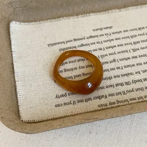 Macro detail of amber resin ring with irregular geometric design on vintage fabric