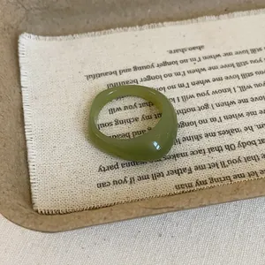 Macro shot of green translucent resin ring with polished finish on rustic burlap