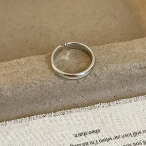 Close-up of polished silver geometric irregular ring showing minimalist adjustable design