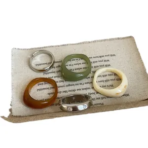 Five-piece minimalist resin and silver metal ring set featuring geometric irregular patterns