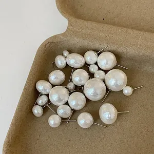 French vintage irregular pearl earrings set displayed on a textured brown tray