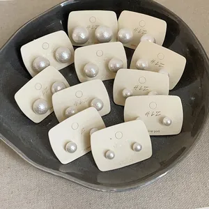 Detailed set of multi-size round white pearl earrings on silver post display cards