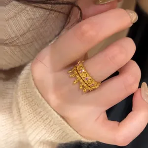 French vintage style gold crown ring set with small pink gemstone on woman's hand