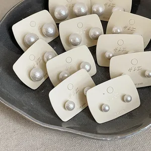 Macro shot of minimalist cream pearl stud earrings with premium silver posts on display