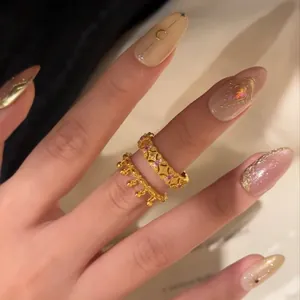 Close-up of vintage gold-plated rings with crown lace and pink crystals on hand