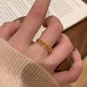 Detailed view of a gold beaded lace ring with an intricate openwork crown-like design