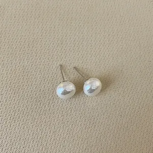 Close-up of French vintage irregular pearl earrings with hammered metal texture