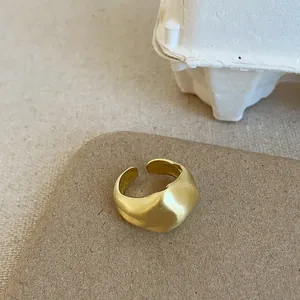 Makroaufnahme der massiven matten Goldring mit Lavastruktur und offenem Band-Design
