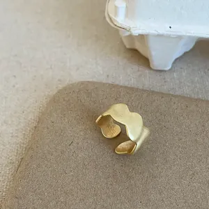 Detail eines mattgoldenen, unregelmäßigen Wellenrings mit strukturierter Oberfläche