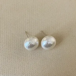 Detailed view of french vintage dome earrings with elegant hammered metal texture