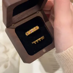 Detailed close-up of vintage gold rings with pink stones in a dark wooden box