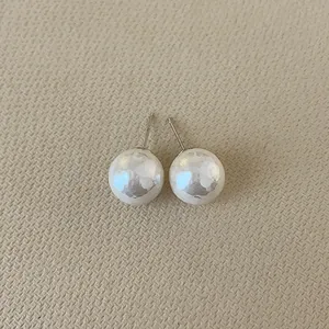 Detailed view of French vintage irregular pearl stud earrings with silver needles