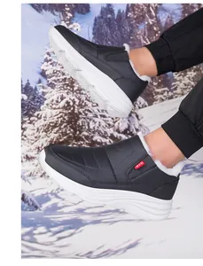 Dettaglio di scarpe invernali senza lacci con fodera in pelliccia bianca su terreno innevato