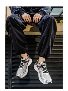 Nahaufnahme modischer silberner Mesh-Sneaker mit dicker weißer Sohle an einem Model