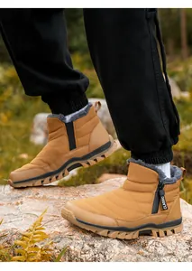 Men's tan waterproof snow boots with fleece lining and thick non-slip soles on a rock