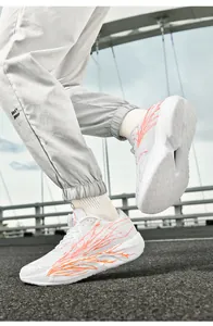 Detail of white running shoes with orange flame patterns and a rotary lacing system