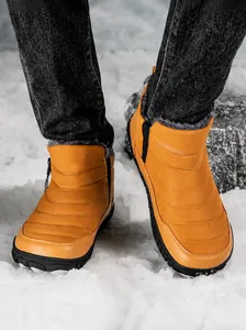 Detail view of ginger yellow waterproof snow boots with warm faux fur lining and side zipper