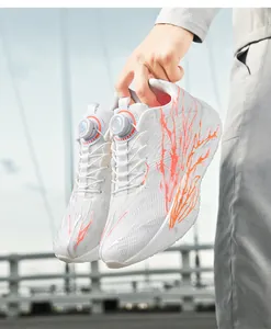 Detail of white knit running shoe with orange flame pattern and rotary dial lacing system