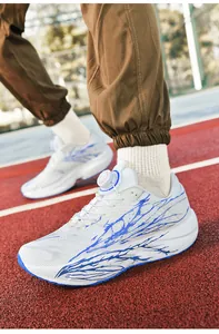 Close-up of white and blue running shoes with knob lacing on a red athletic track