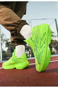 Dynamic low-angle shot of fluorescent green marathon running shoes on a red track