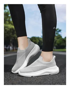 Detailansicht der grauen Mesh-Sneaker zum Slipper-Stil am Fuß auf Asphalt