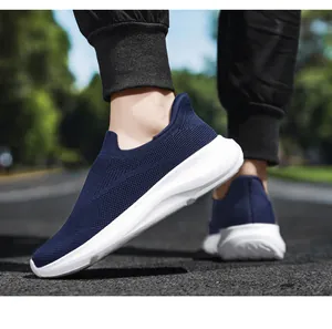 Detail von dunkelblauen Slip-On-Sneakern mit atmungsaktivem Mesh auf einem Gehweg